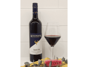 Image of a bottle of Ambriels Gift alongside a glass of red wine.