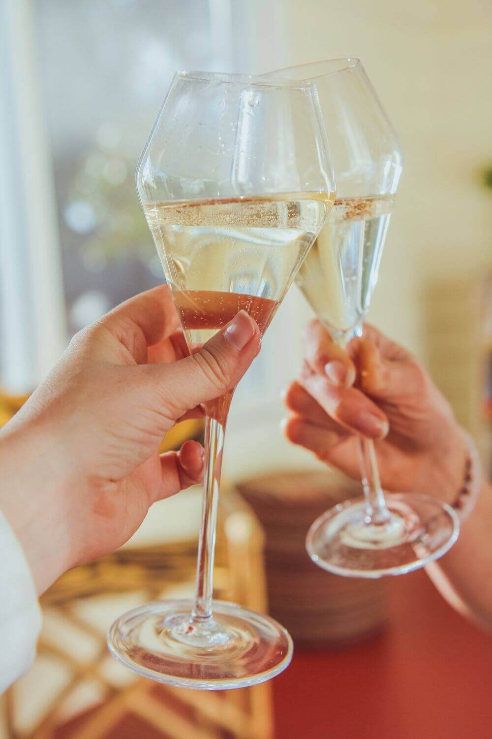 Two people toasting with our Savor Sparkling Glasses