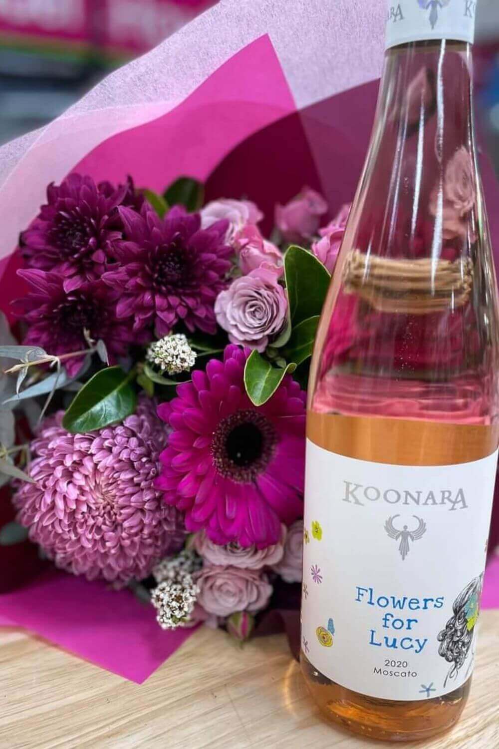 Flowers for Lucy Moscato wine along side a bright pink bunch of flowers